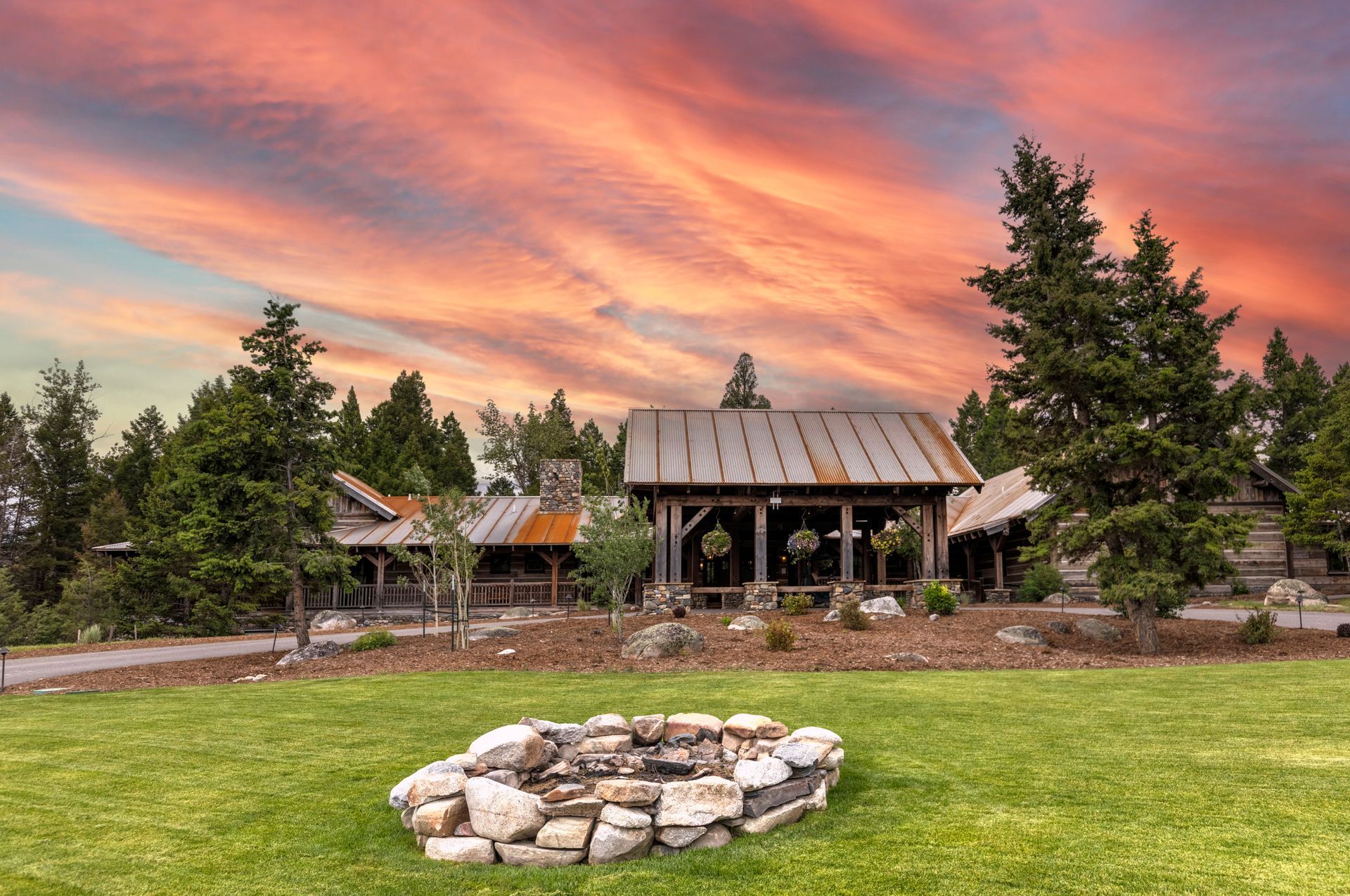 There is a fire pit in the middle of the grass in front of a house.