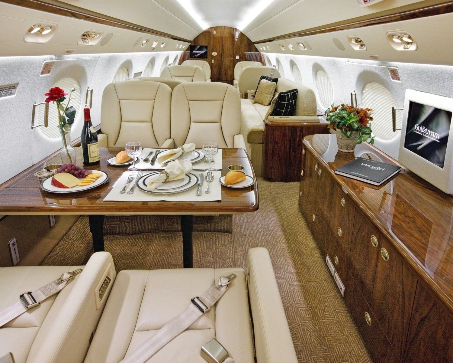 The inside of a private jet with a table and chairs