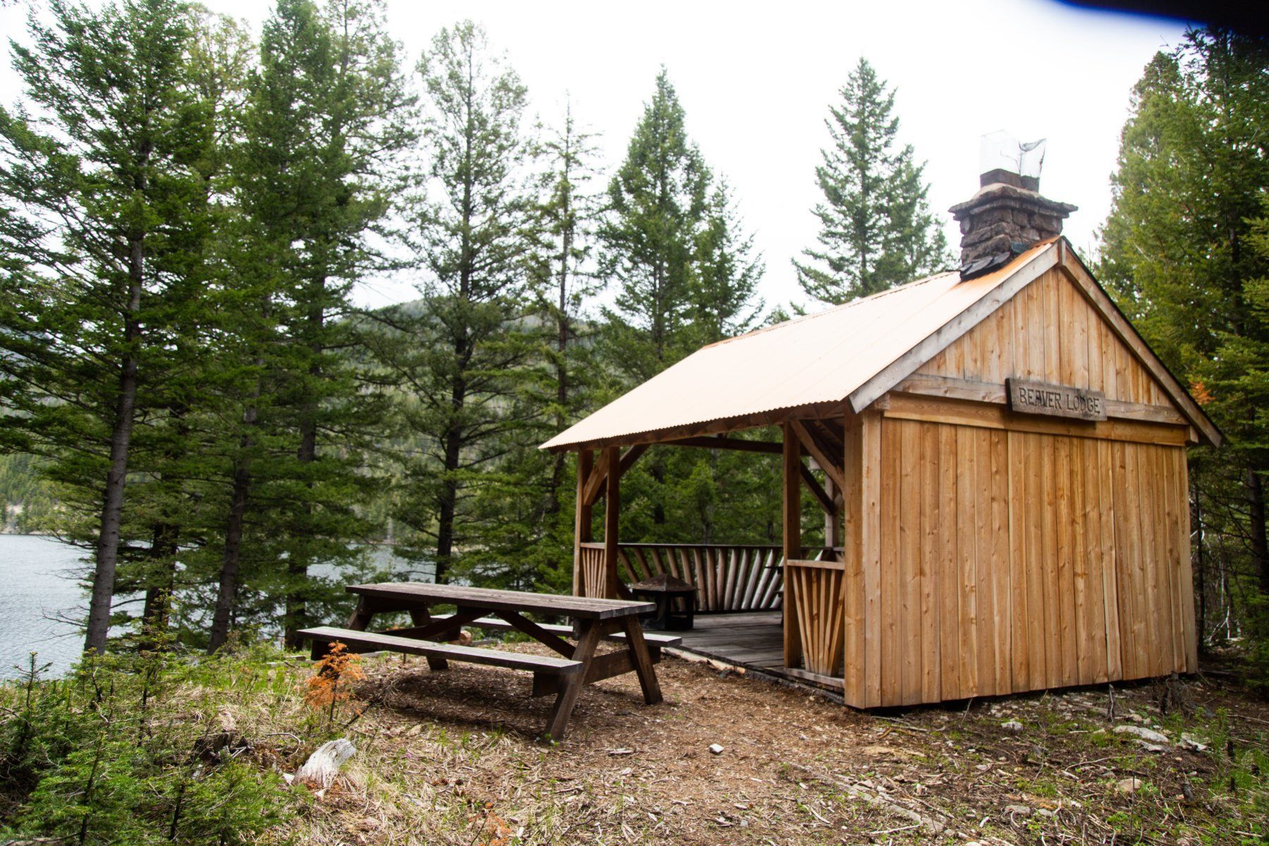 A small wooden hut with a picnic table in front of it