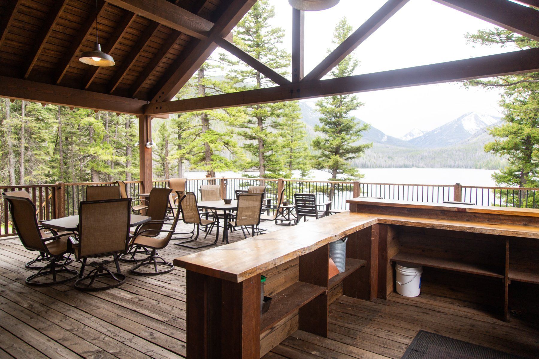 A wooden deck with tables and chairs and a bar