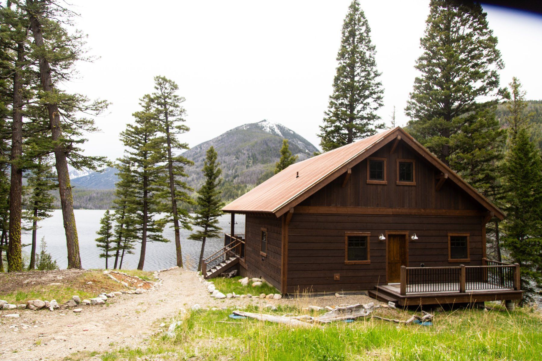 A cabin in the woods with a lake in the background