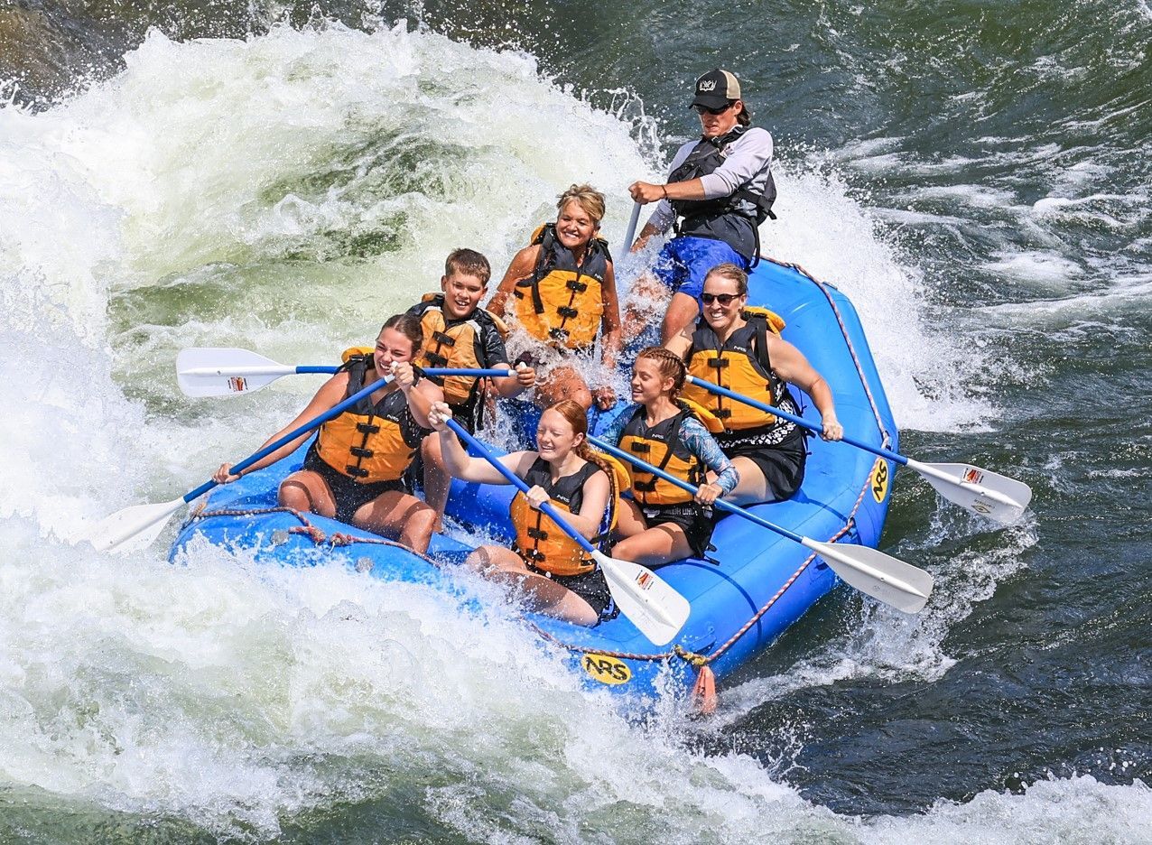 A group of people are rafting down a river in a raft.