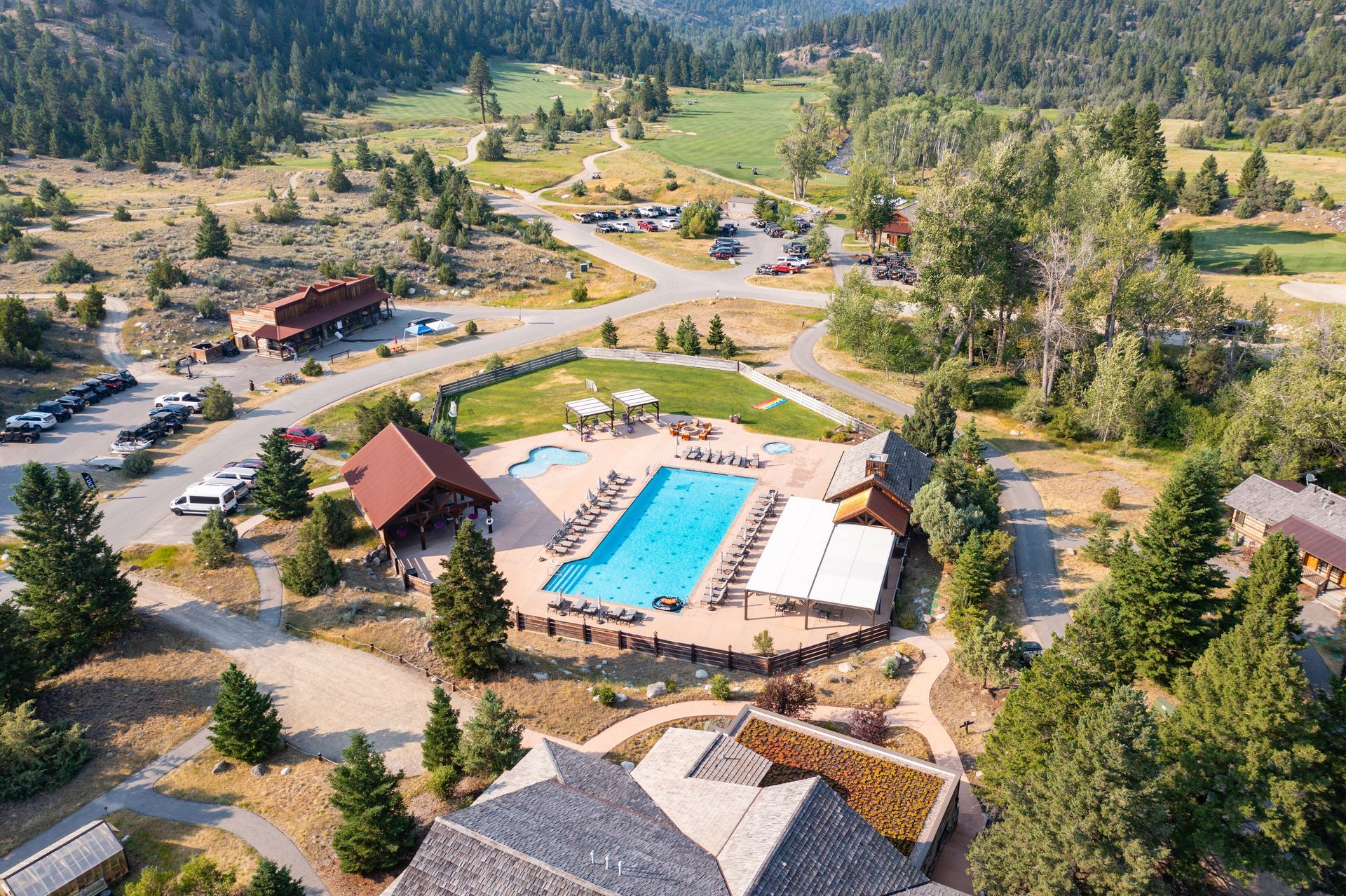 An aerial view of a swimming pool surrounded by trees and buildings.