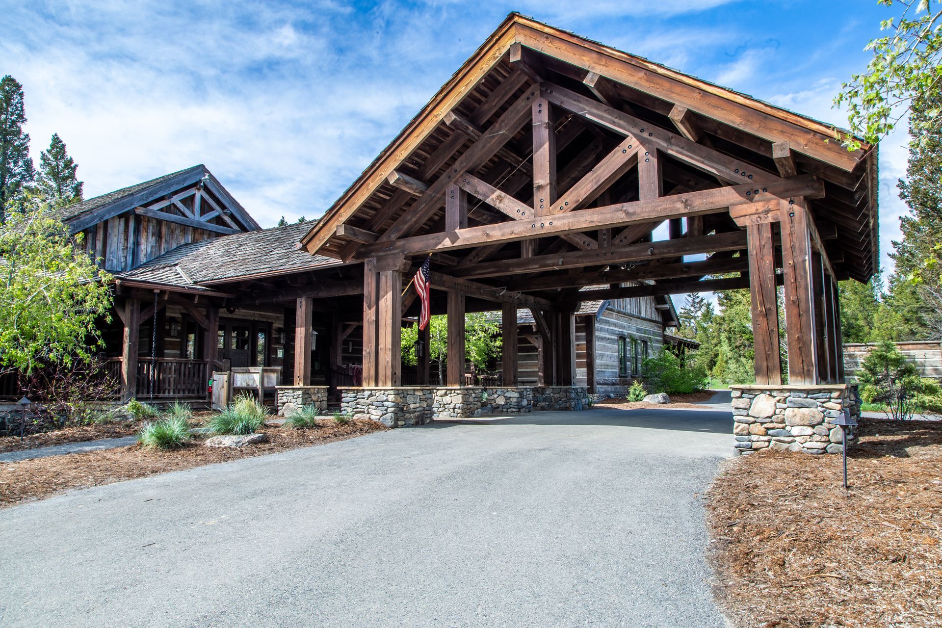 A large wooden building with a driveway leading to it