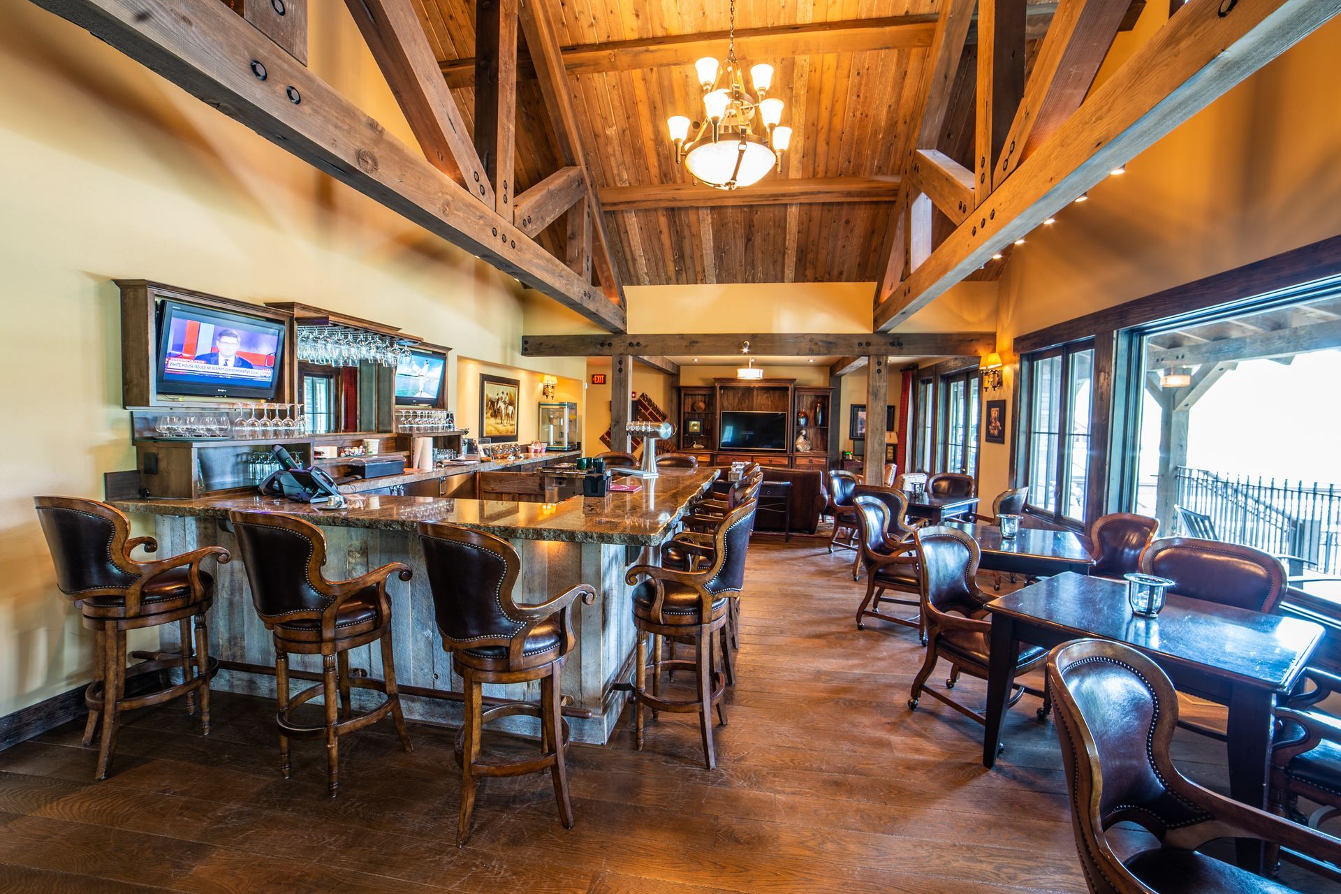 A large room with tables and chairs and a bar.