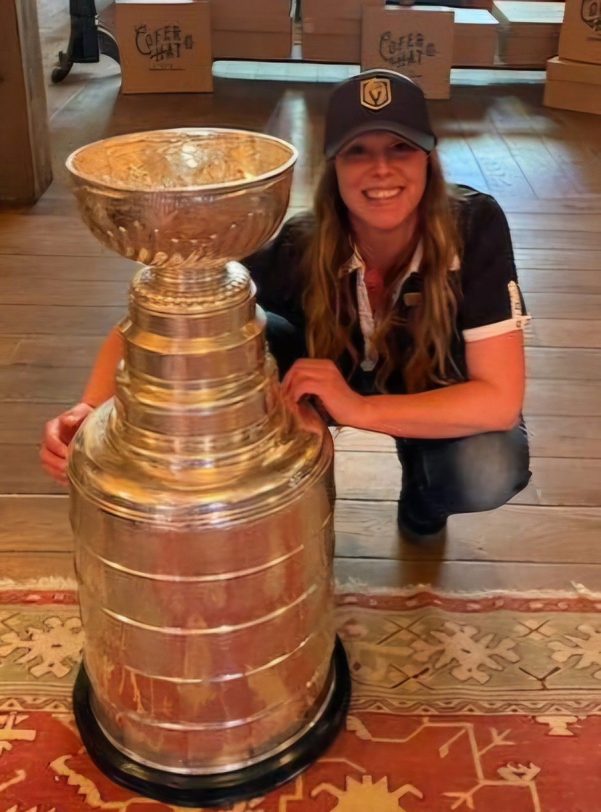 A woman wearing a white shirt and a necklace smiles for the camera