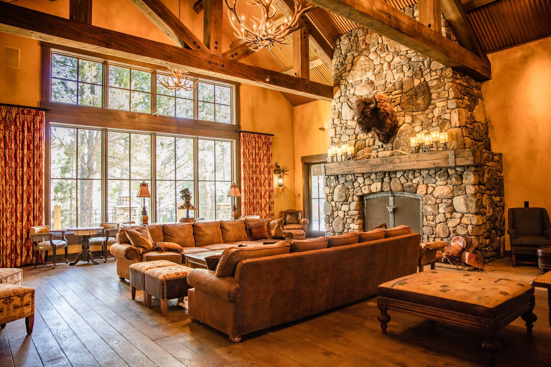 A living room with a stone fireplace and a large sectional couch