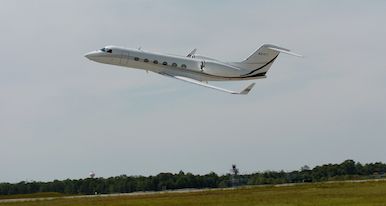 A private jet is taking off from an airport runway.