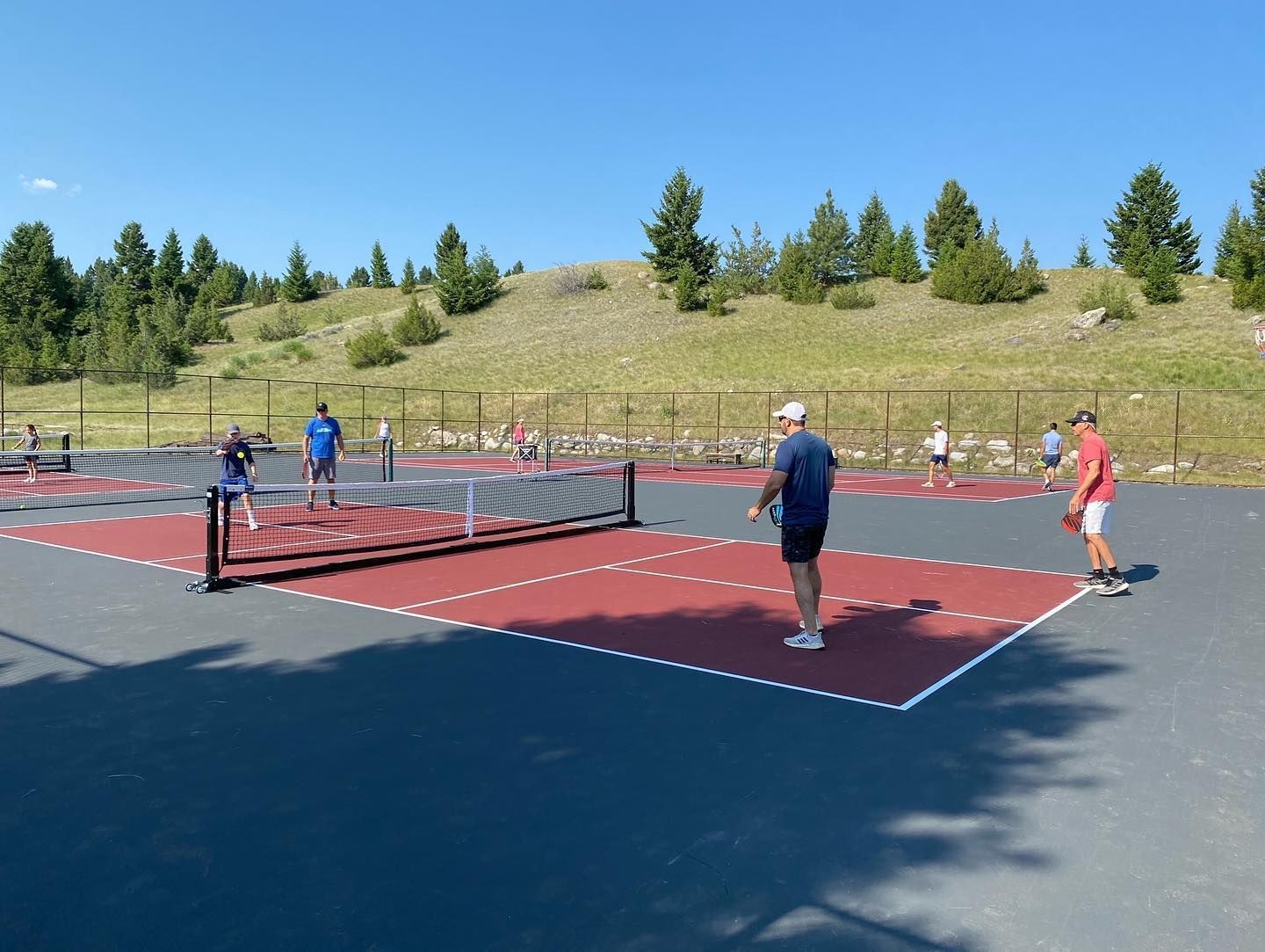 A group of people are playing tennis on a court.