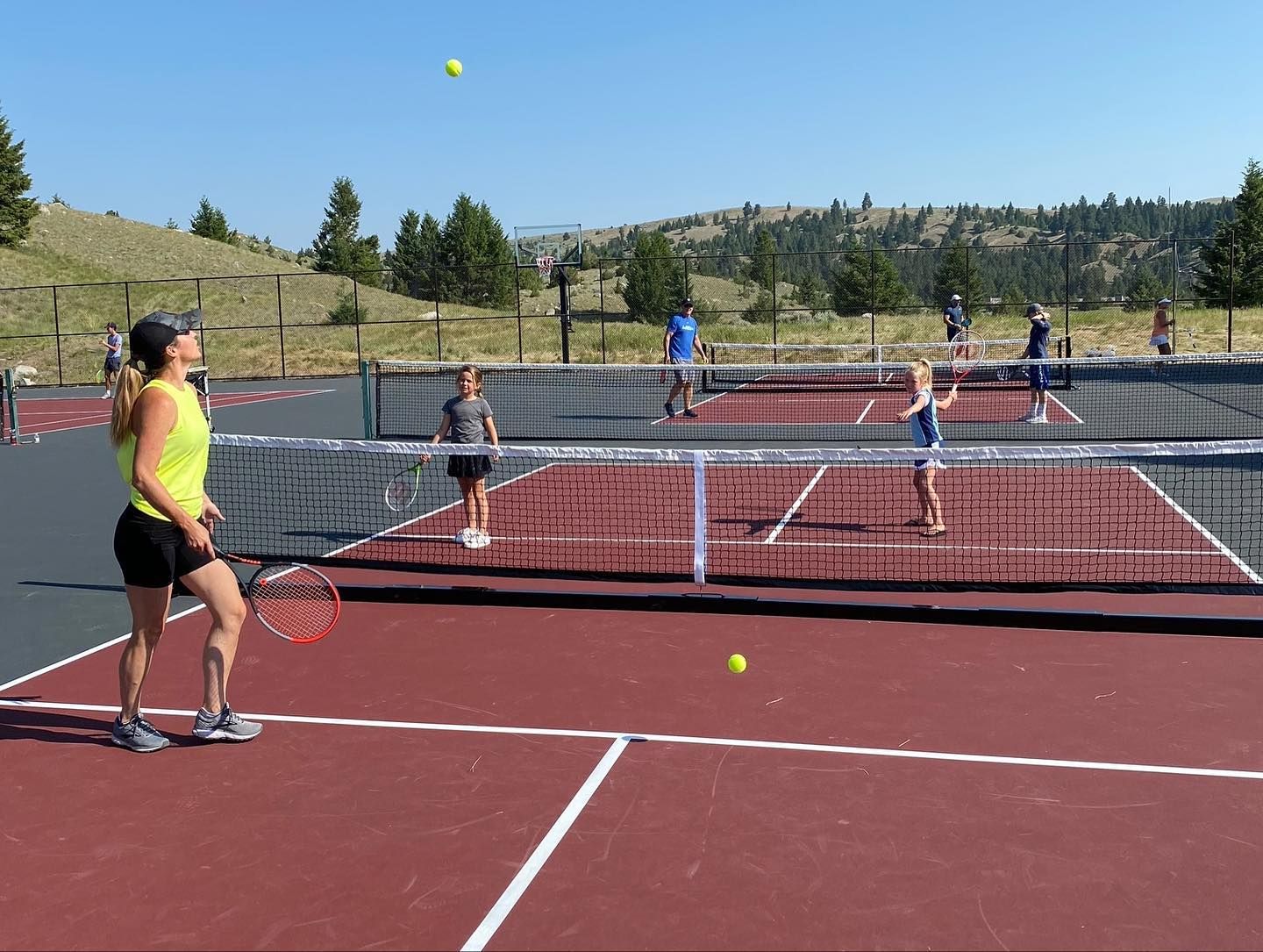 A group of people are playing tennis on a tennis court.