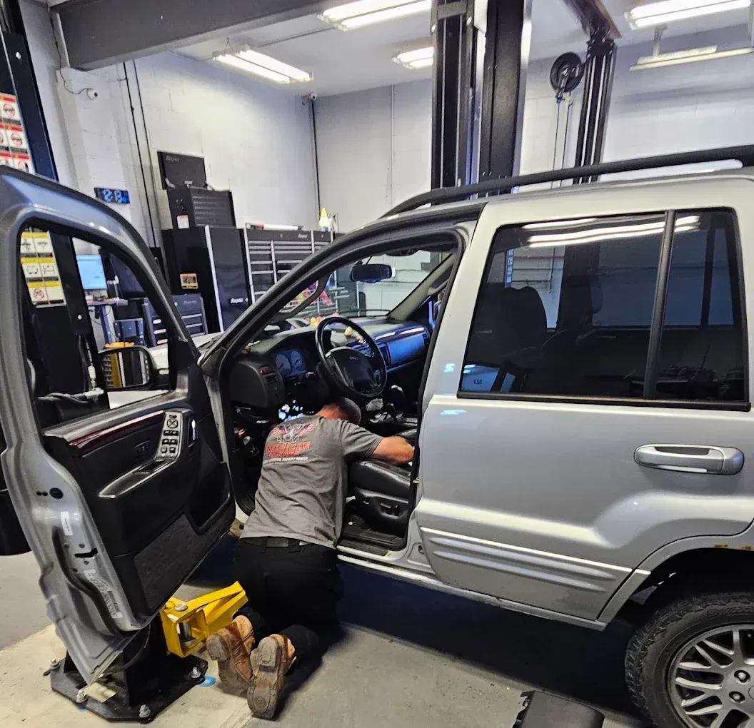 Mechanic Fixing Wirings | American Garage