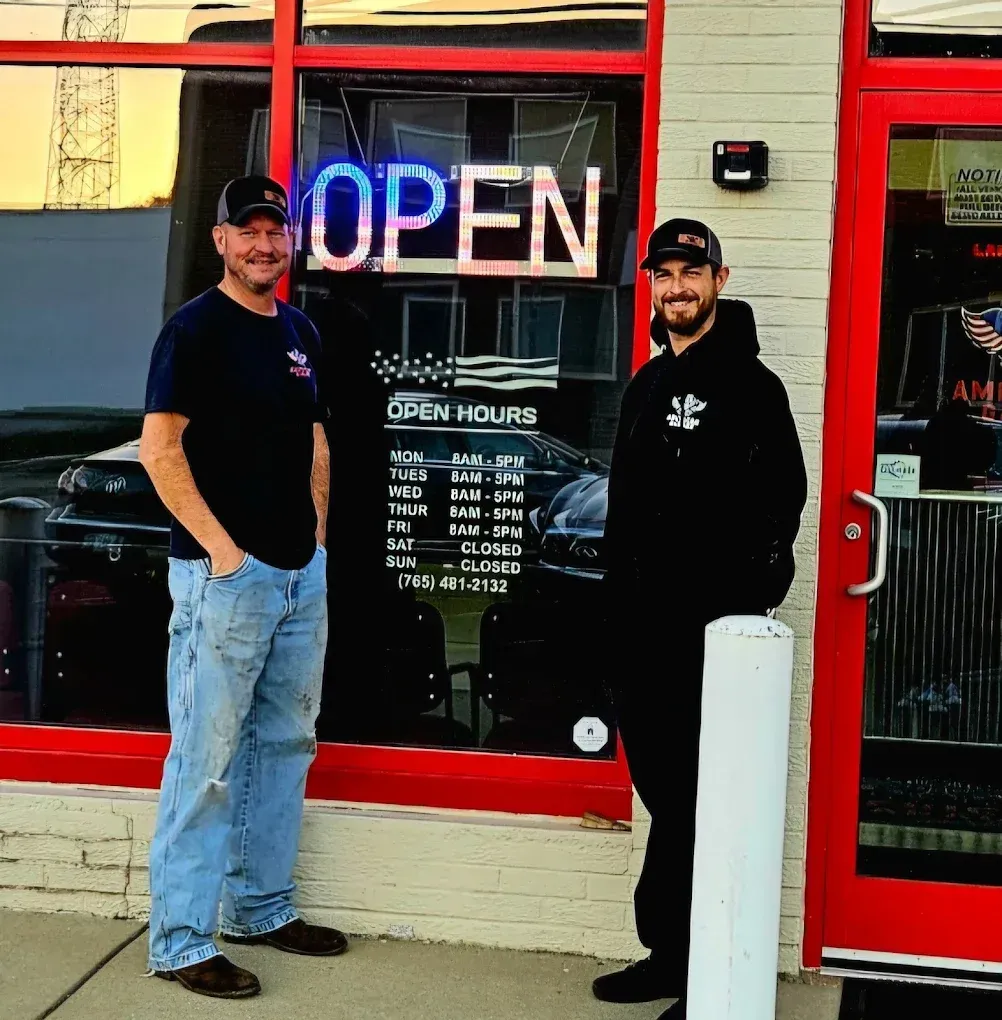 Owners In Front Of Shop Window | American Garage