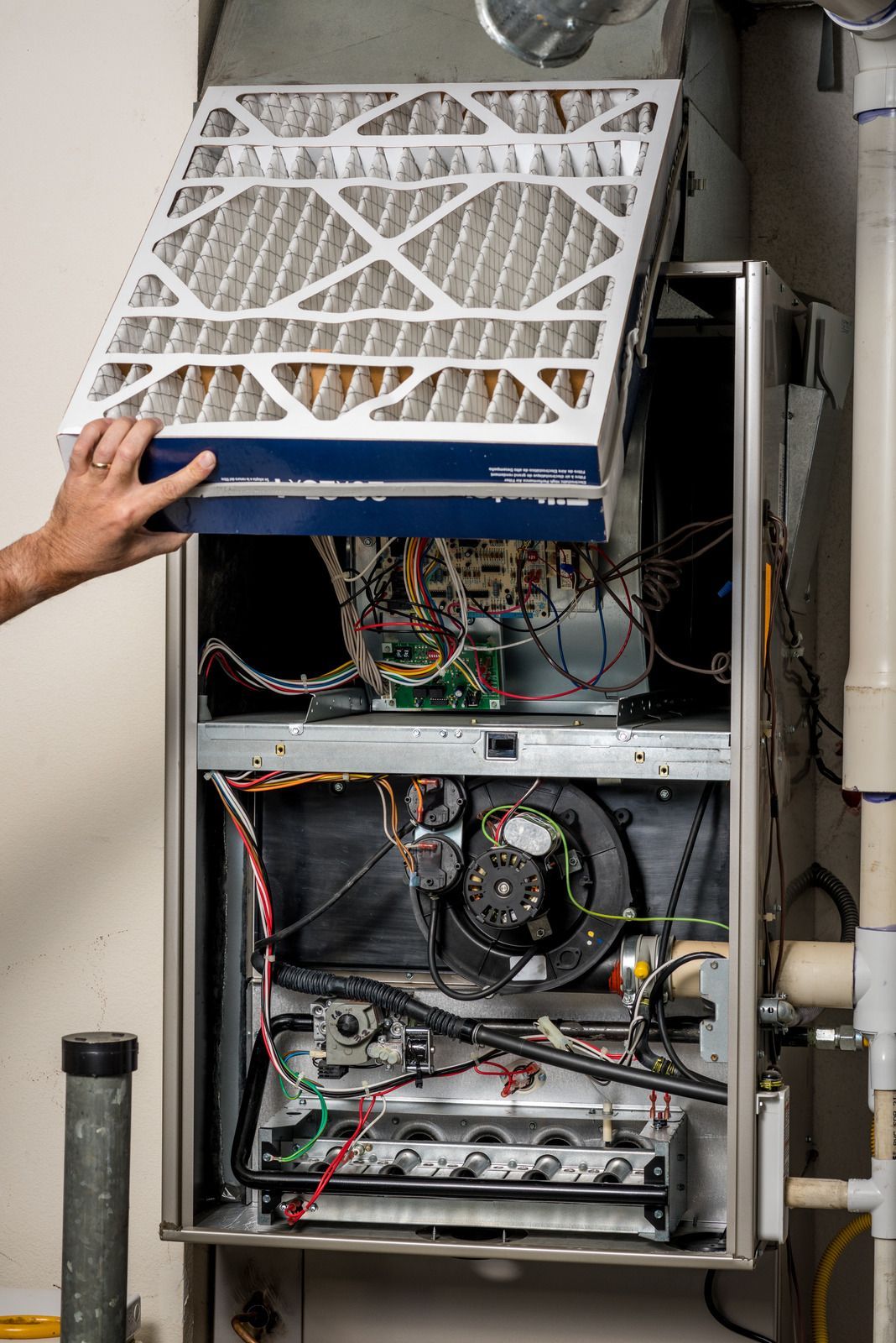 A person is cleaning a furnace with a filter.