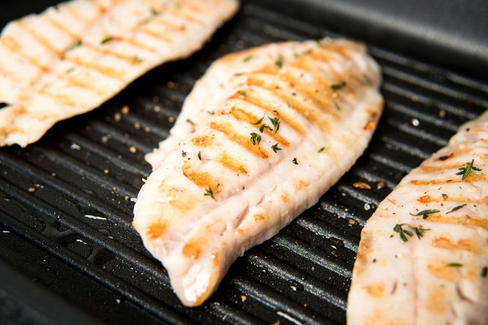 Fish Being Grilled On A Grill Pan — Mulgrave Seafoods In Bungalow, QLD