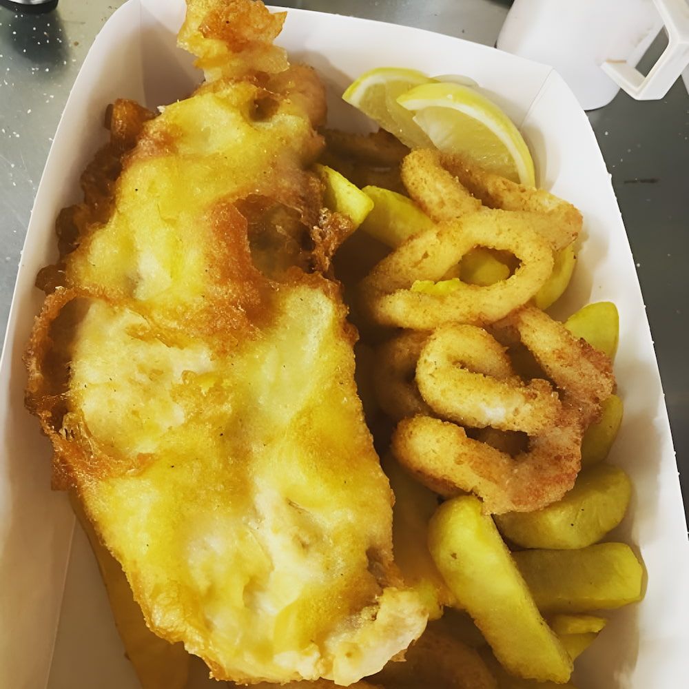 A Cardboard Box Filled With Fried Fish And French Fries — Mulgrave Seafoods In Bungalow, QLD