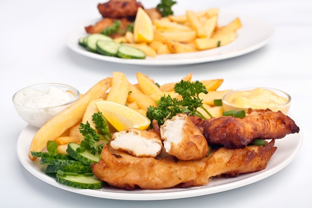 Two Plates of Fish and French Fries on a Table — Mulgrave Seafoods In Bungalow, QLD