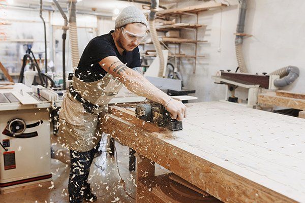 Carpenter Working with Electric Planer on Wooden Plank — Thatcher, AZ — Woodside Construction, LLC