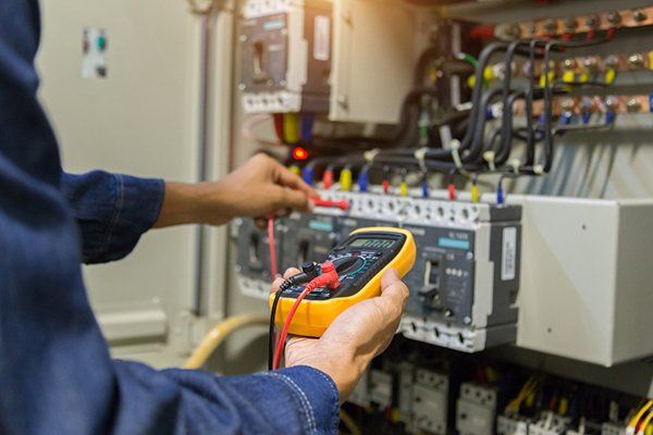 Electrician Measuring Voltage in Electrical Cabinet Control — Thatcher, AZ — Woodside Construction, LLC