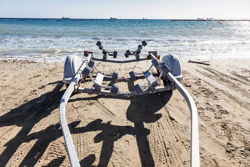 A Boat Trailer on the Beach Next to the Ocean — Mackay Marine Services in Airlie Beach, QLD