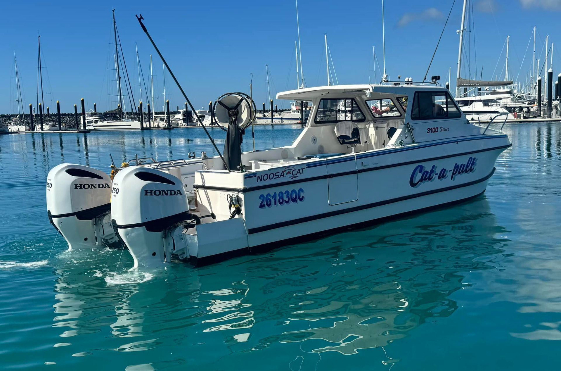 White fishing boat with two engines on blue water, 