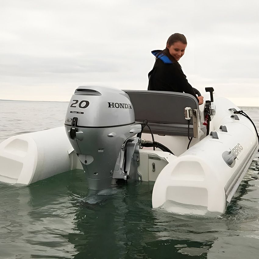 A Woman is Sitting on a Boat with a Honda Motor — Mackay Marine Services in Mackay, QLD