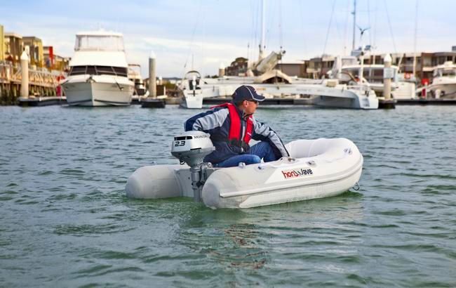 Person in a Small Inflatable Boat on Water Near Docked Boats, Wearing a Life Vest — TJM Rockhampton in Rockhampton City, QLD