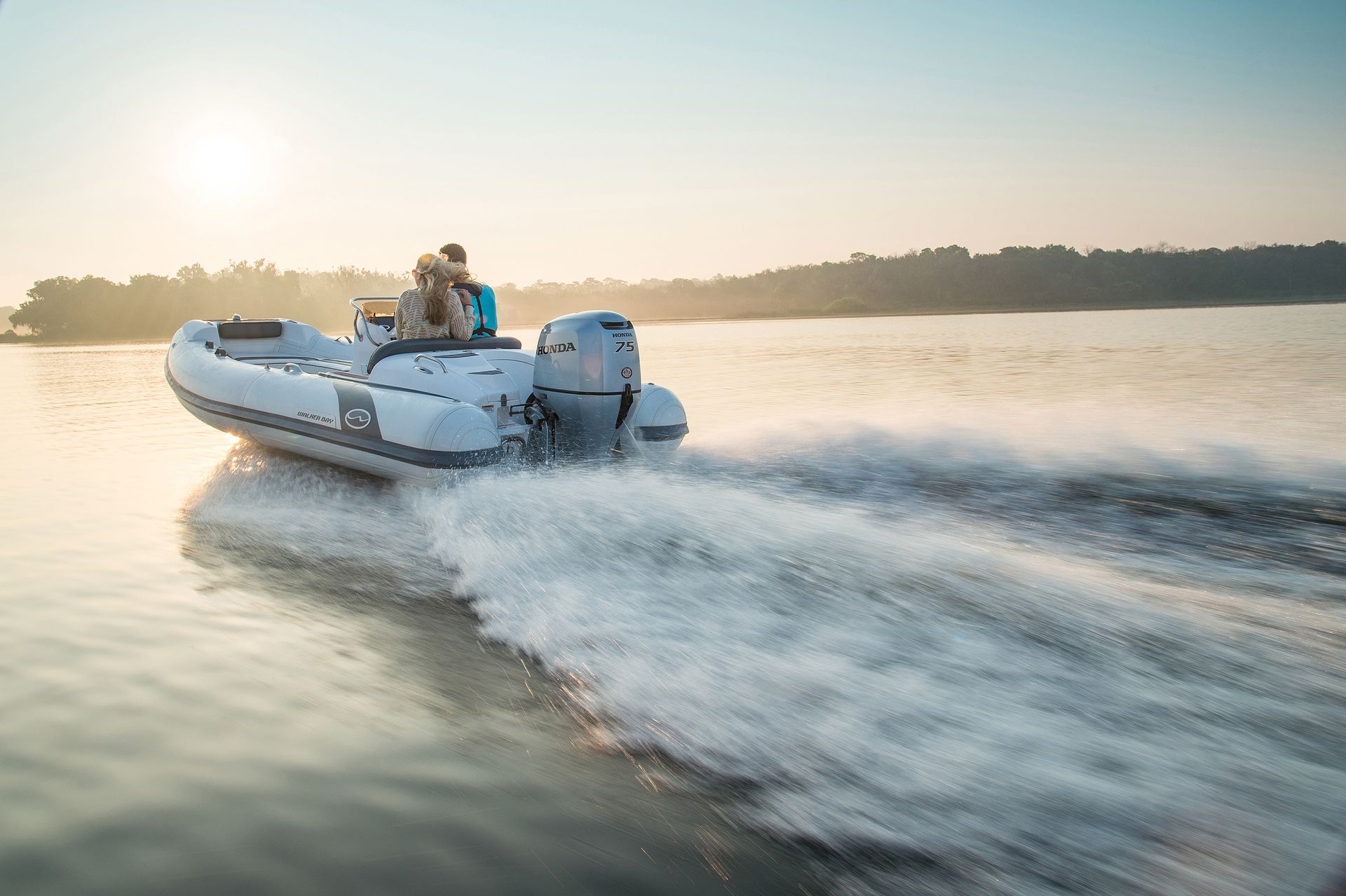 a White Inflatable Boat With Two People Speeds Across the Water — TJM Rockhampton in Rockhampton City, QLD