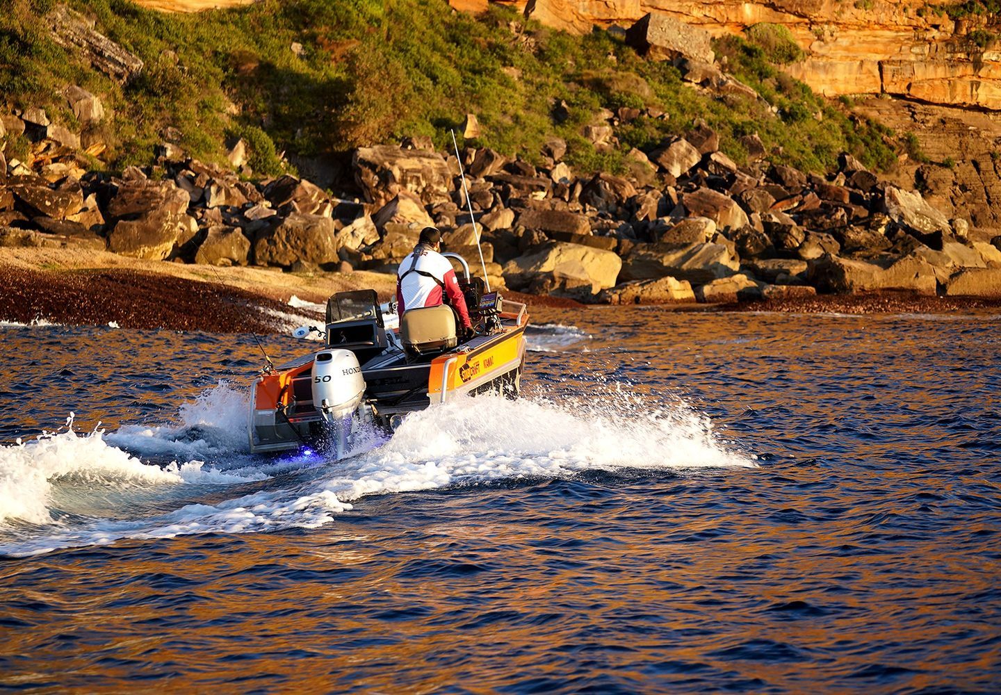a Motorboat Speeds Across Blue Water, Creating White Splashes — TJM Rockhampton in Rockhampton City, QLD