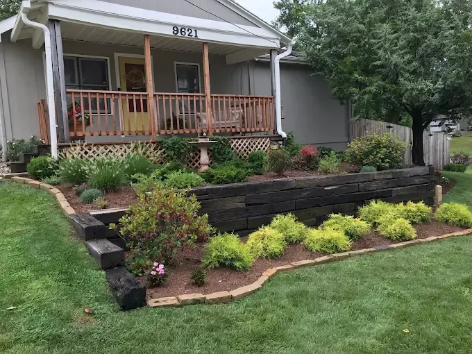 A house with a porch and a lush green lawn in front of it.