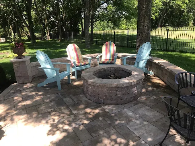 A fire pit with chairs around it in a backyard.