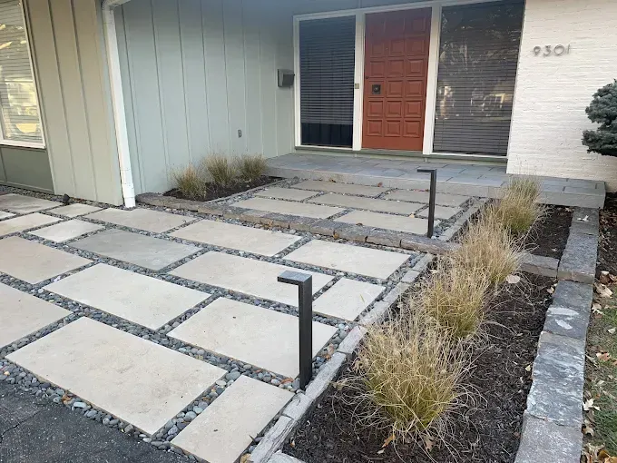 A brick walkway leading to the front door of a house