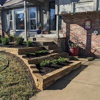 A brick house with a brick walkway and a brick planter in front of it.
