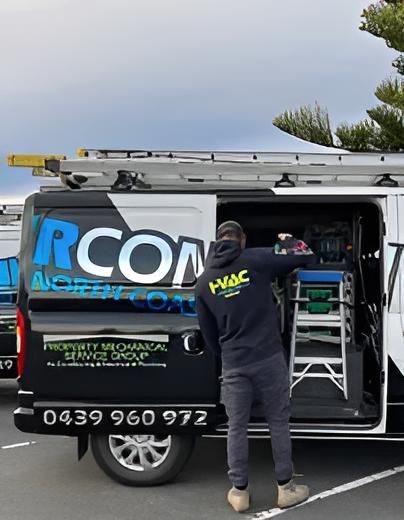 A Man is Standing in Front of a Van — Sparky Mid North Coast In Forster, NSW