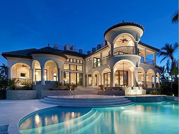 A large house with a swimming pool in front of it