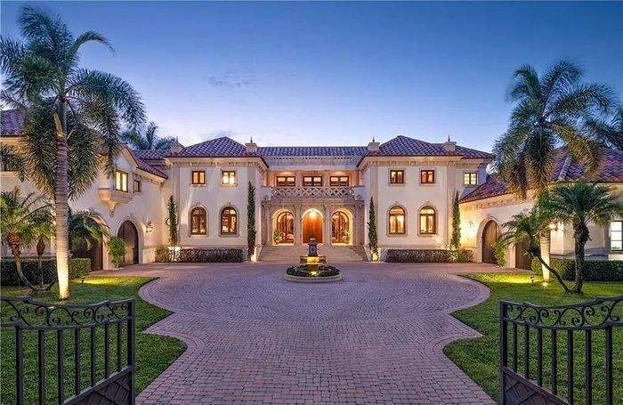 A large house with a brick driveway leading to it