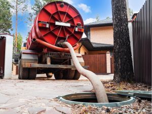 A vacuum truck is pumping water into a septic tank.