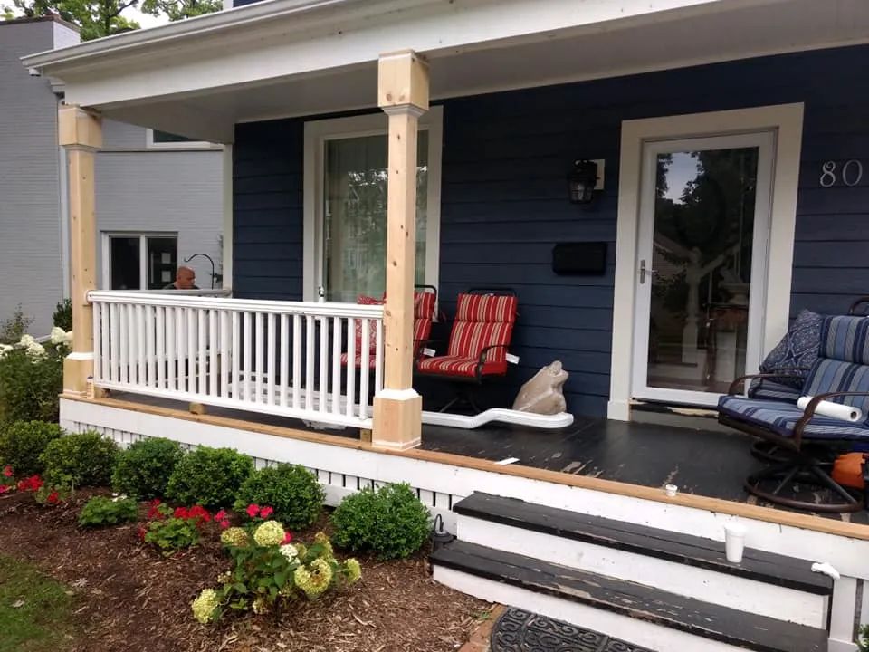Blue house with white porch, railing, and steps; two unfinished wooden support posts.