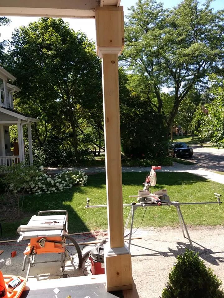 Wooden porch post being worked on with tools on the ground.
