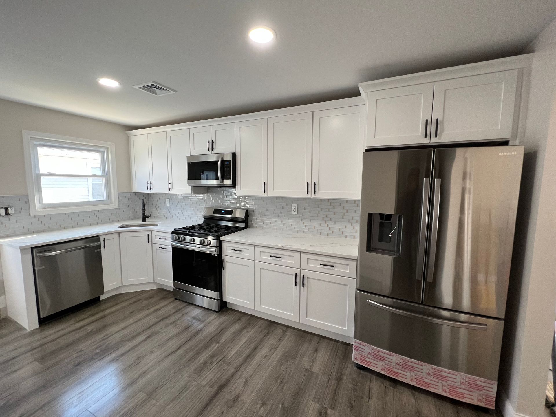 A kitchen with white cabinets and stainless steel appliances.