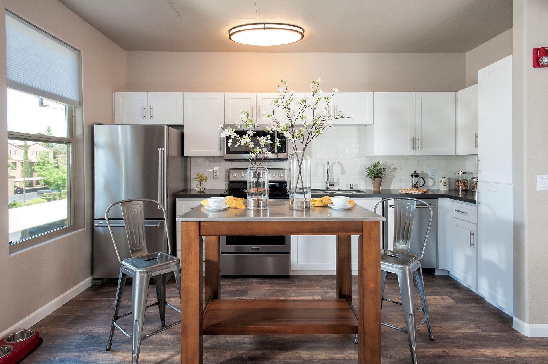 Bright modern kitchen with white cabinets, stainless steel appliances, and a wooden island.