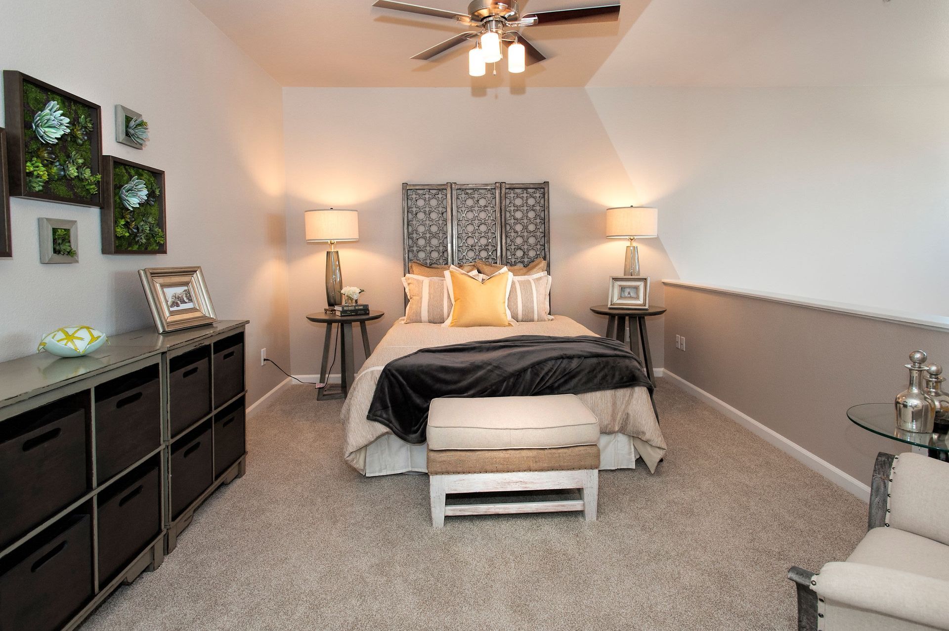 Cozy apartment bedroom with bed, two nightstands, lamps, a bench at the foot, and a dresser.