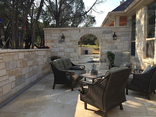Pool with a wooden structure overhead, a hot tub, and lounge chairs on a patio under cloudy skies.
