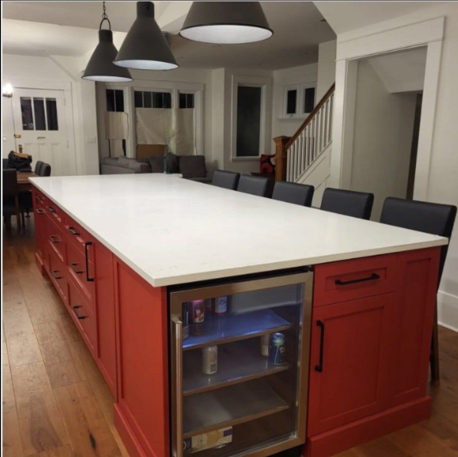 A kitchen with red cabinets and a white counter top