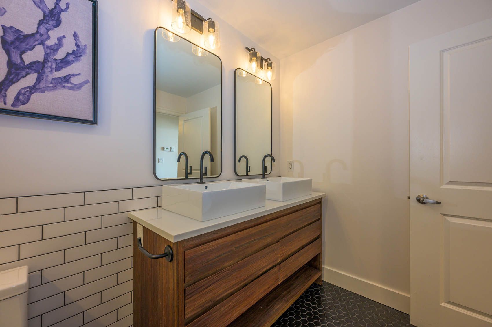 A bathroom with two sinks and two mirrors.