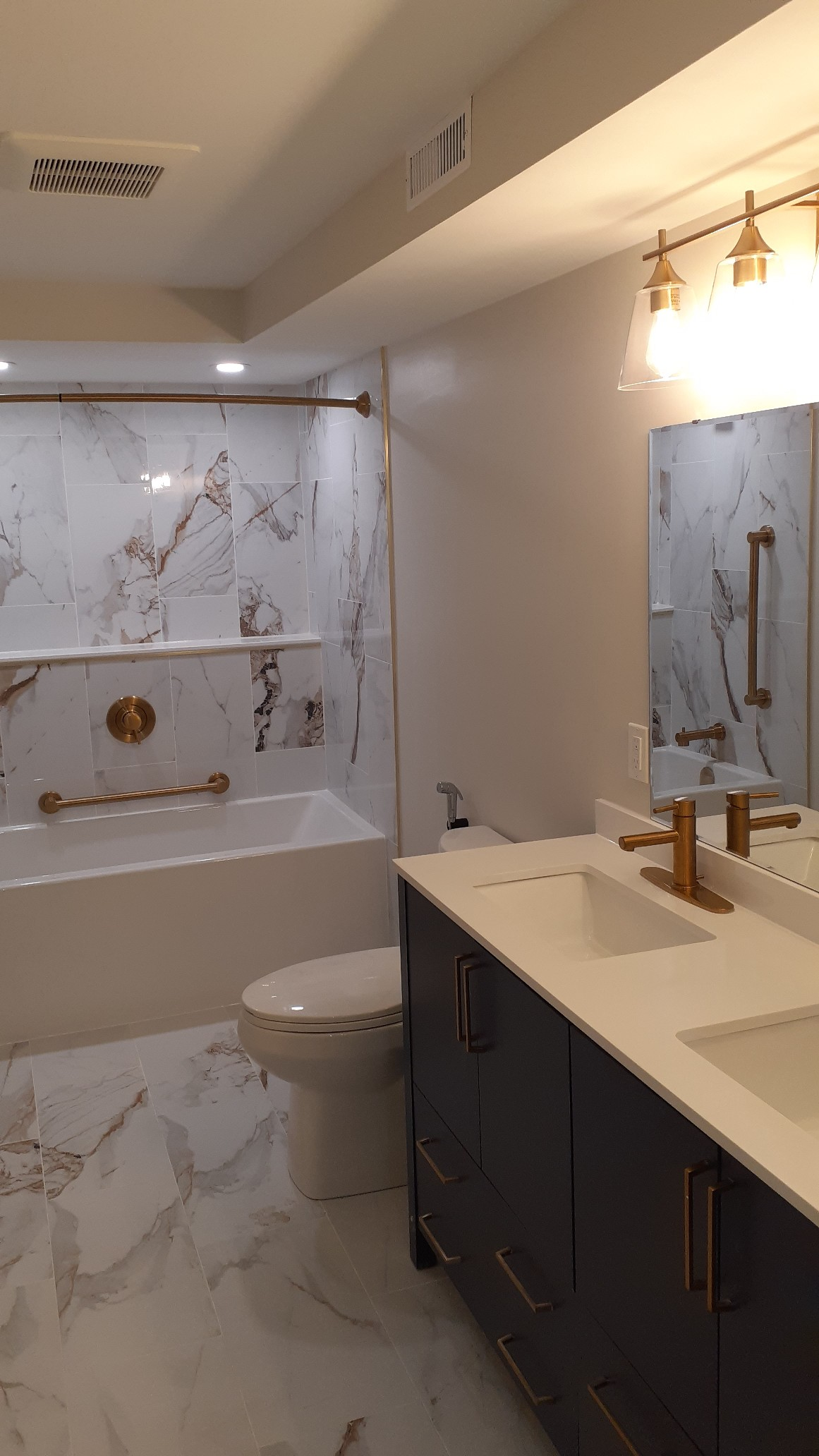 A bathroom with two sinks , a toilet , and a bathtub.