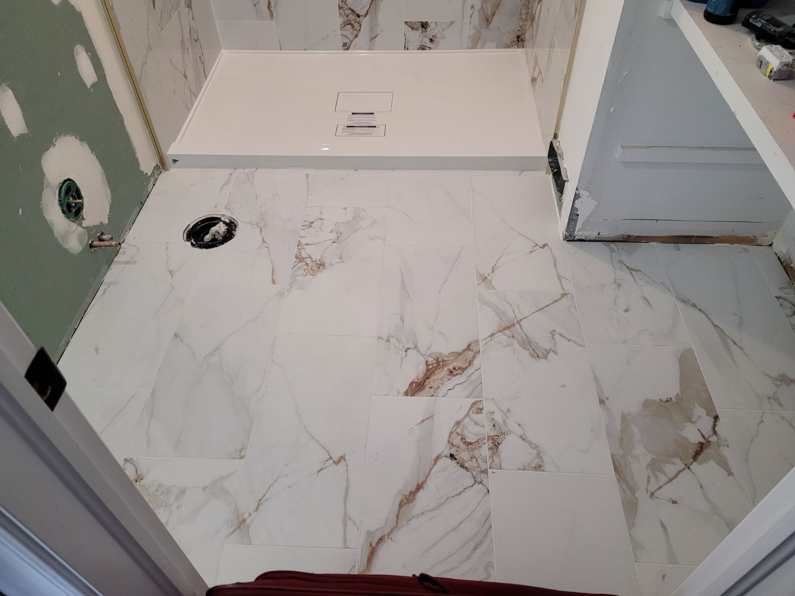 A bathroom with marble floors and a walk in shower