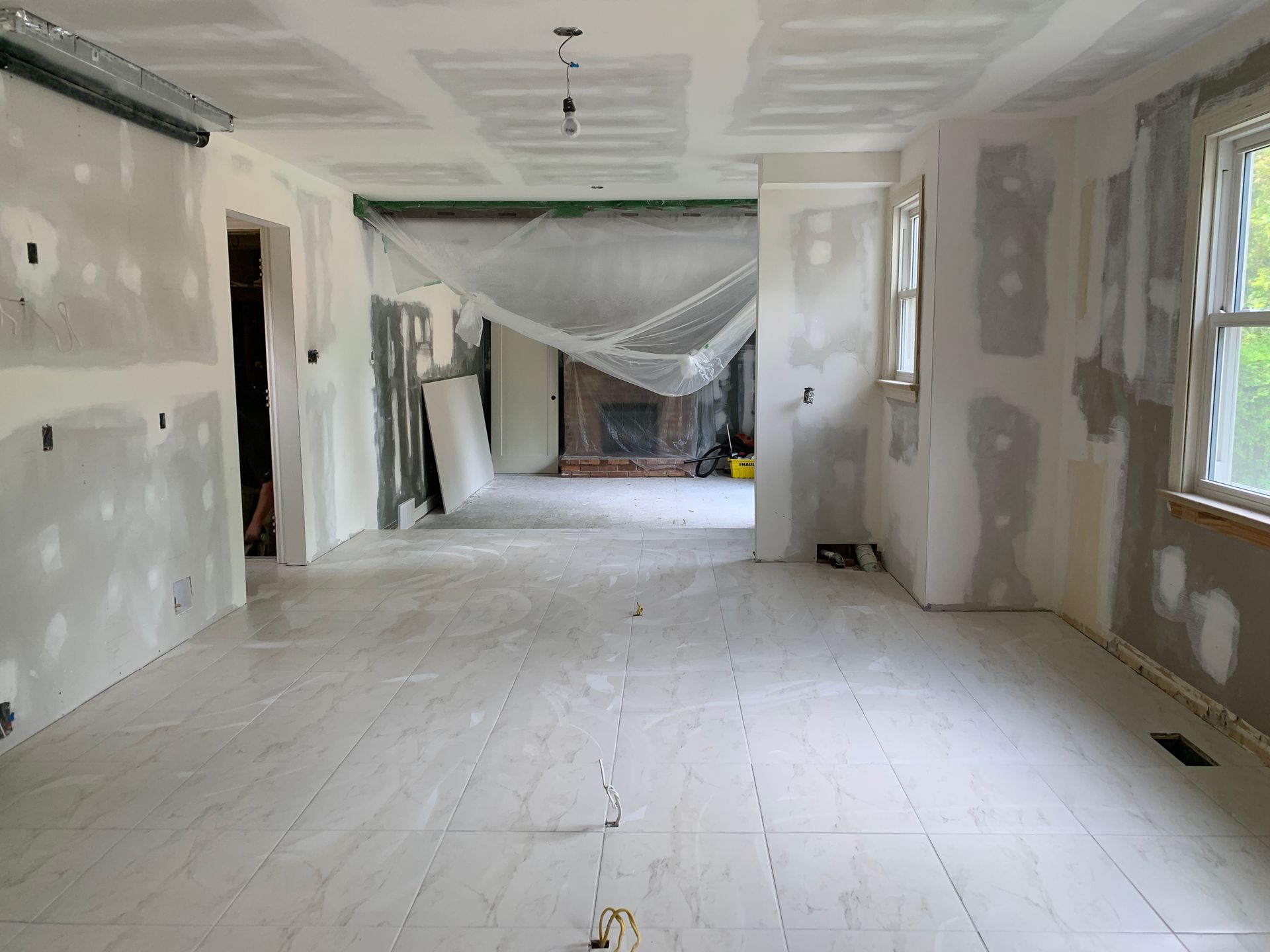 A large empty room with white walls and a fireplace.