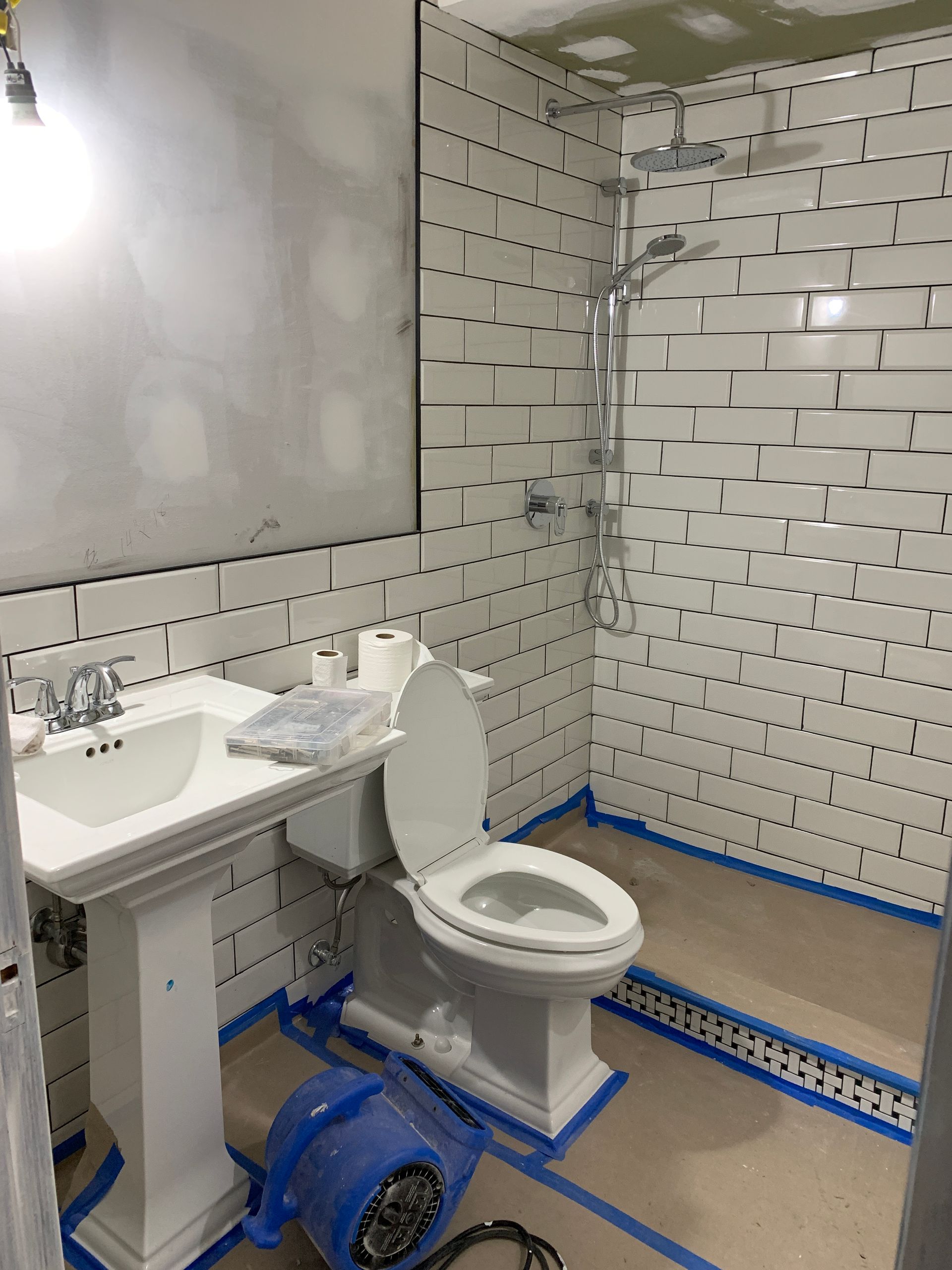 A bathroom with a toilet , sink and shower being remodeled