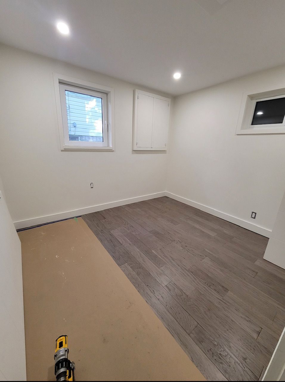 An empty room with a wooden floor and a window.