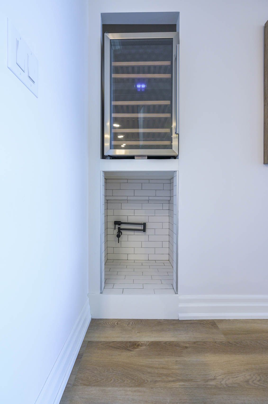 There is a wine cooler in the corner of the room.